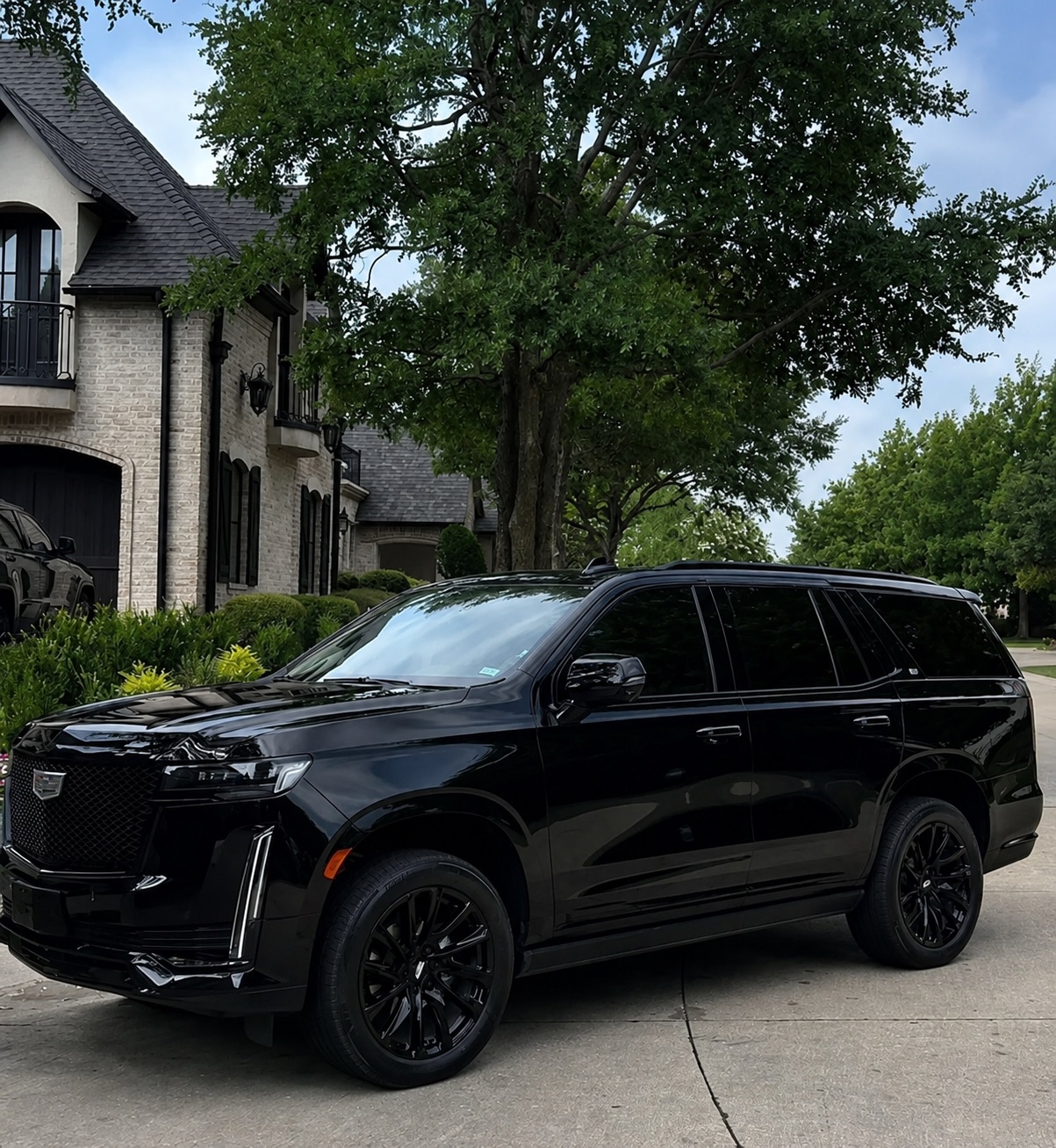 Black Cadillac Escalade in the driveway of a luxury estate
