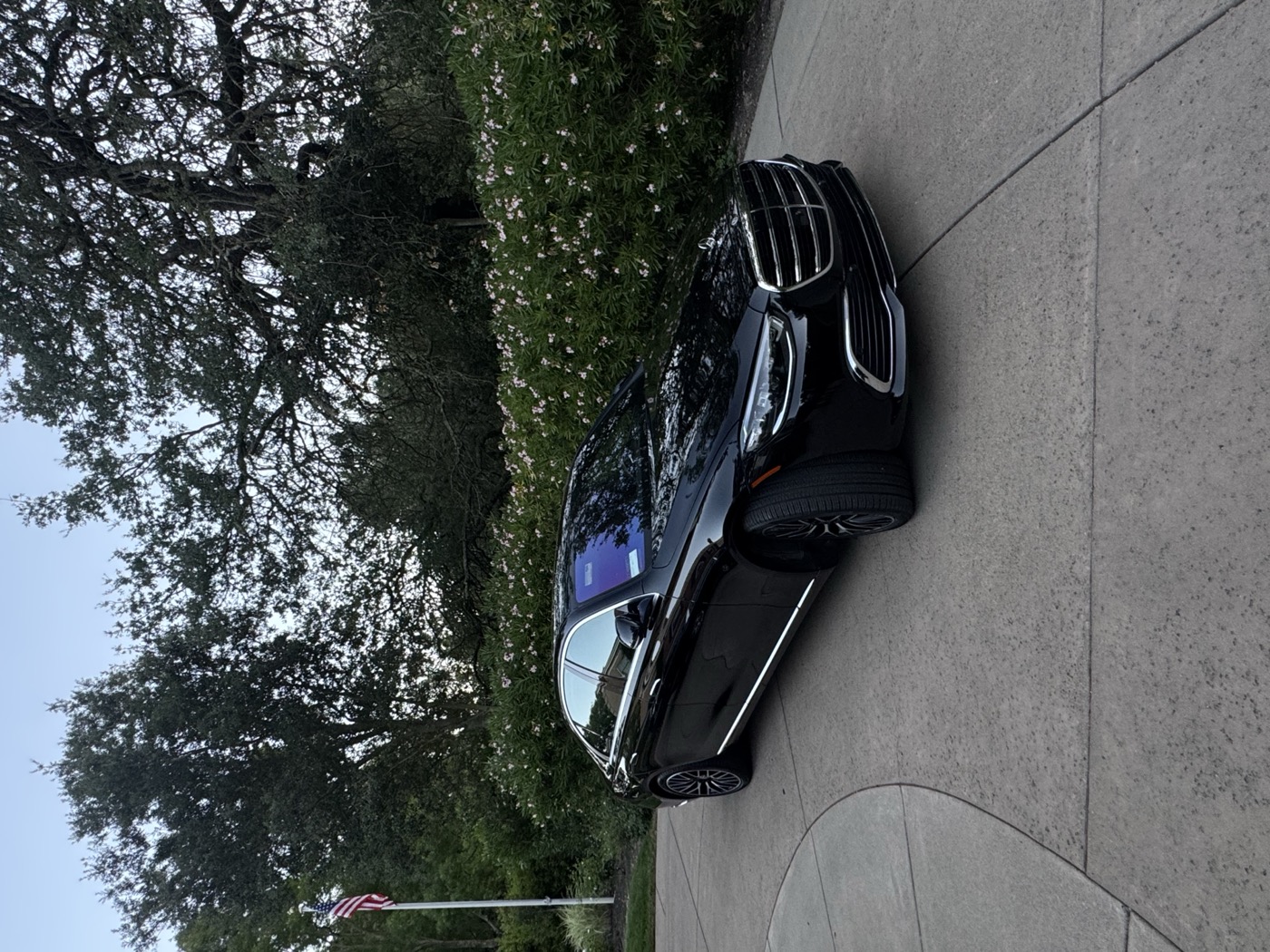 Black executive vehicle detailed and ready in a private driveway