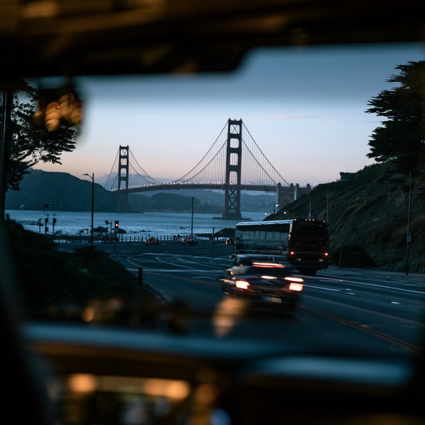 Charter bus and traffic near the Golden Gate Bridge at dusk