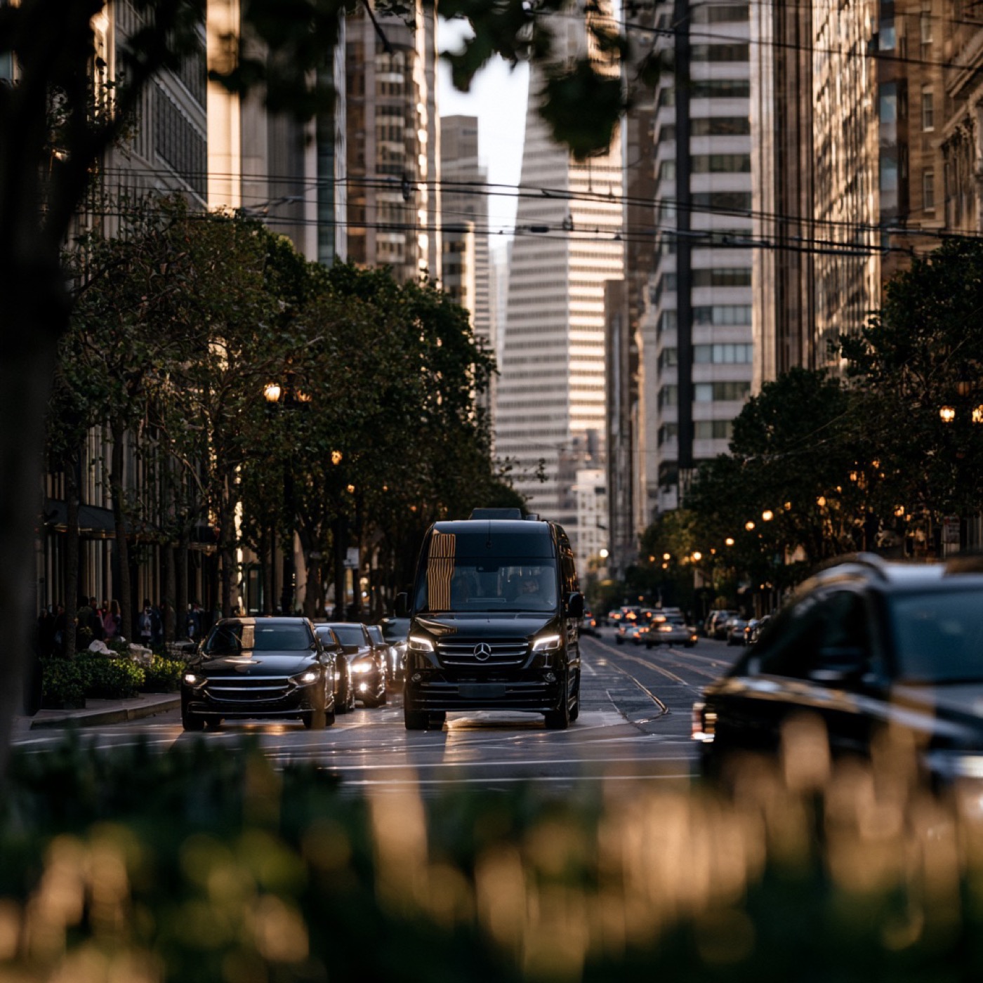Black Mercedes-Benz Sprinter van on a downtown San Francisco street at dusk